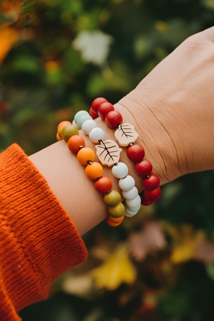 Wooden bracelets made from painted beads in fall colors, adorned with tiny wooden leaf or pumpkin charms