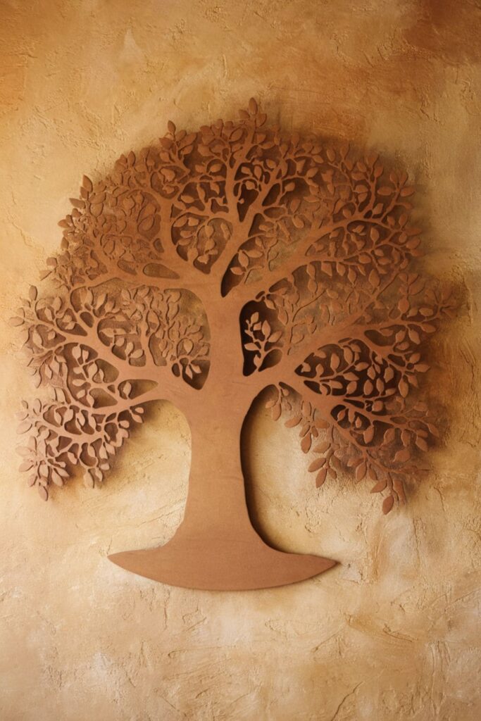 Large cardboard tree silhouette with detailed branches and leaves, painted in natural tones and mounted on a textured wall