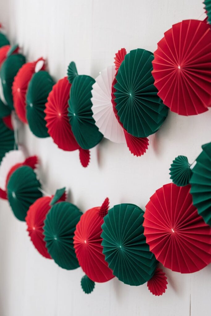 A vibrant paper rosette garland hanging on a white backdrop