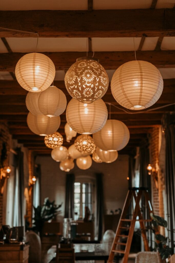 Beautifully crafted paper lanterns glowing softly with battery-operated tea lights inside, hanging from tree branches at dusk