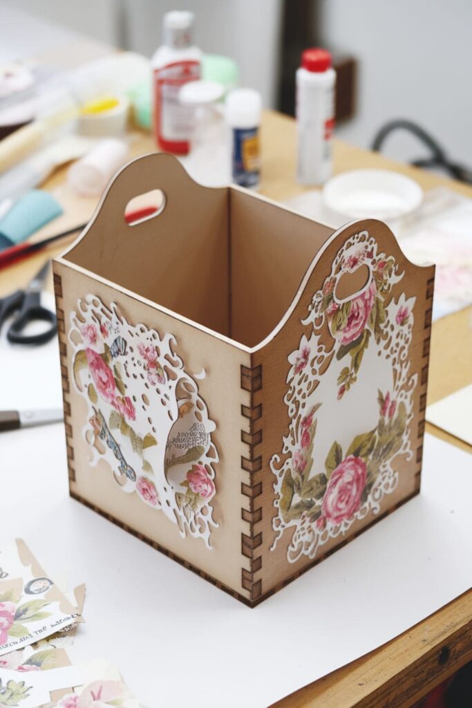 Decorated wooden box with vintage paper cutouts and a glossy finish