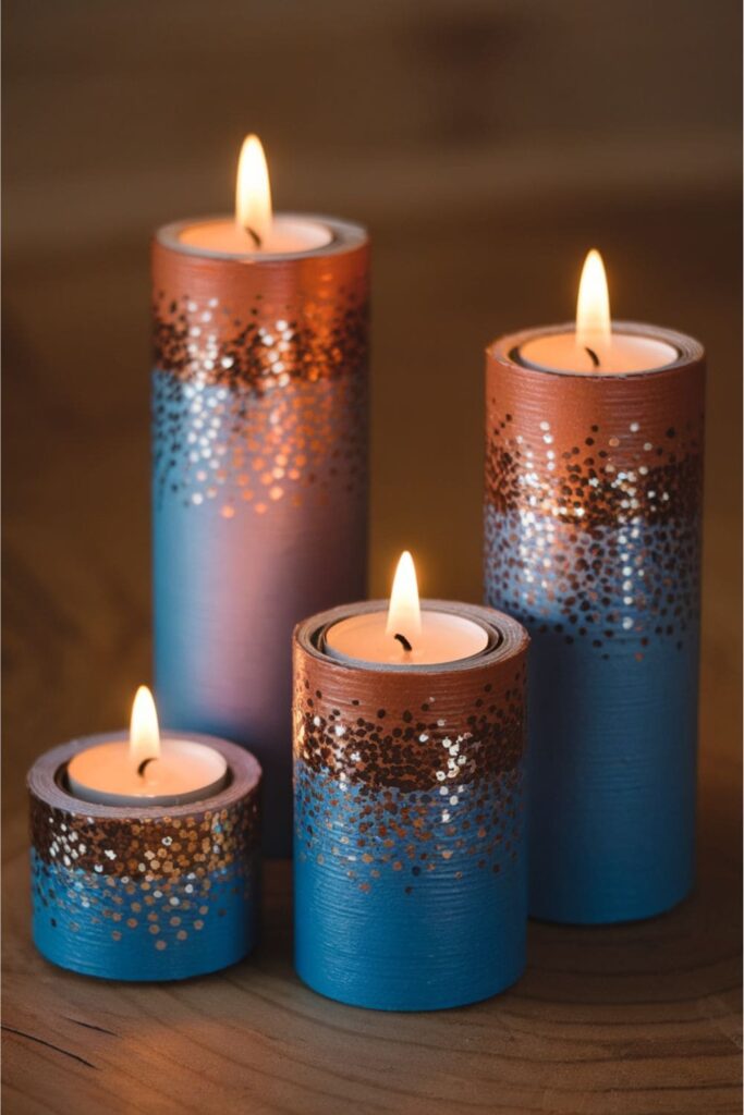 Festive candleholders made from cardboard rolls painted metallic, featuring glitter and holding safe battery-operated tea lights