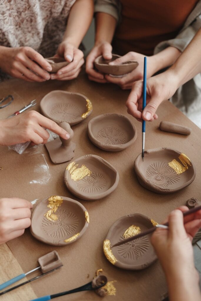 Small clay dishes being shaped and painted with unique designs