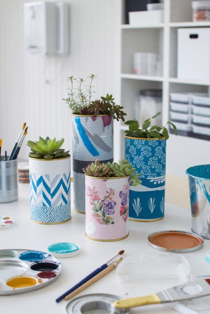 Tin cans decorated and used as colorful planters for small plants