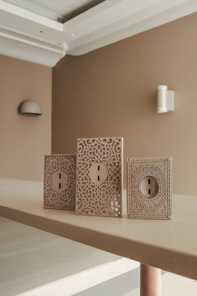 Beige outlet covers with intricate patterns on a table in a modern room