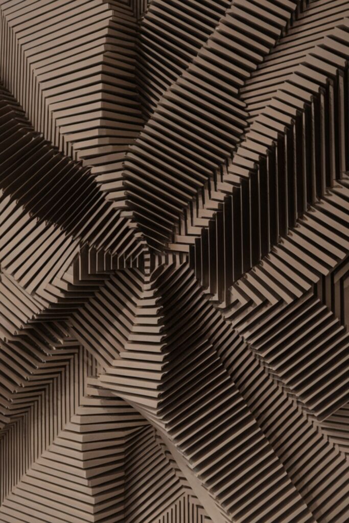 Black-and-white optical illusion wall art with layered 3D cardboard shapes