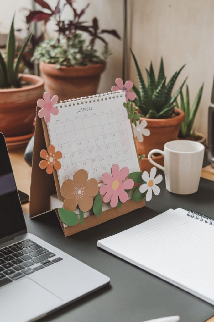 Cardboard desk calendar stand with flower-shaped holders on a work desk