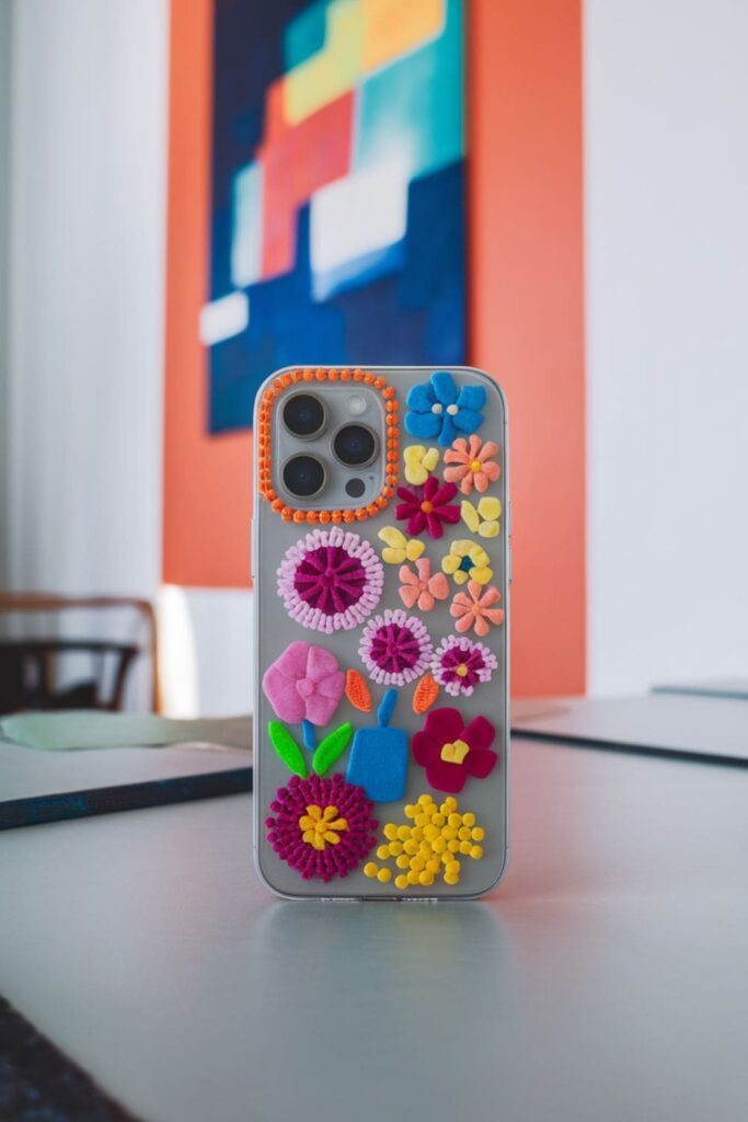 Colorful hot glue phone case with abstract patterns on a table