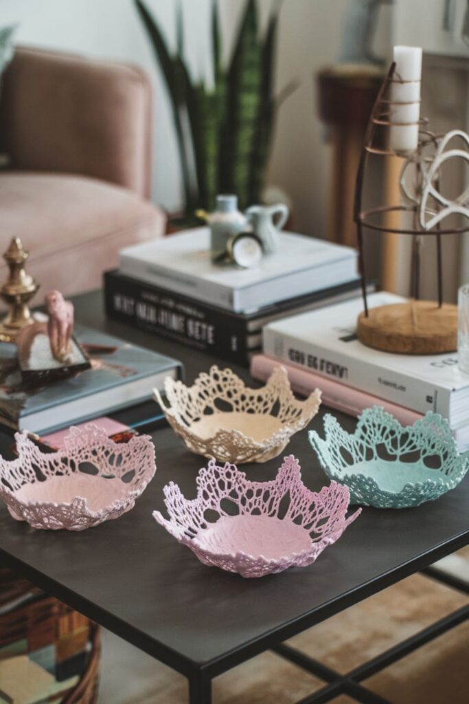 Delicate hot glue lace bowl in pastel colors on a table