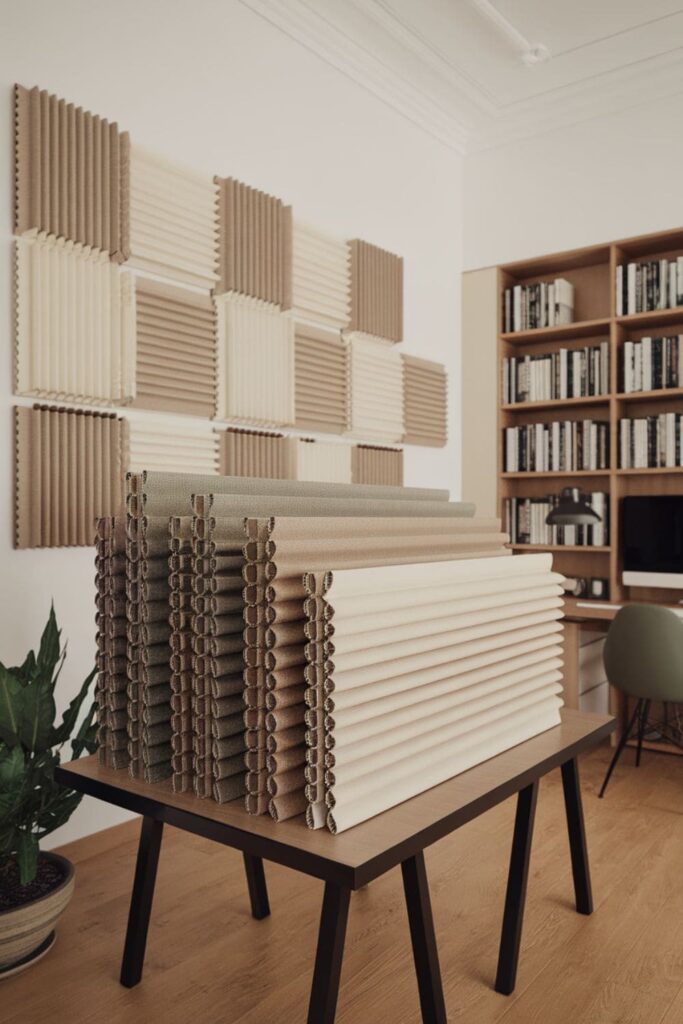 Fabric-covered cardboard acoustic panels in neutral tones on a table