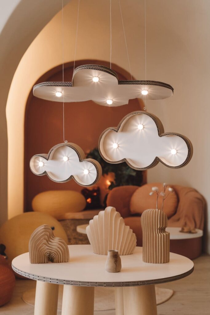 Organic-shaped cardboard clouds with LED lights on a table