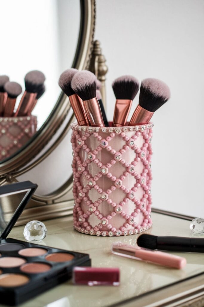 Pink lattice makeup brush holder with crystals on a vanity table