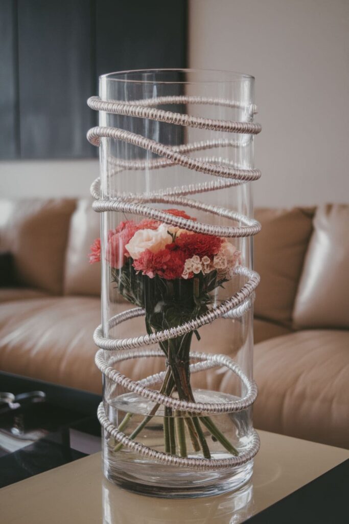 Silver vase with hot glue spirals on a table in a modern living room